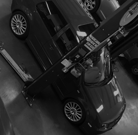 Black and white image of a car in a repair shop
